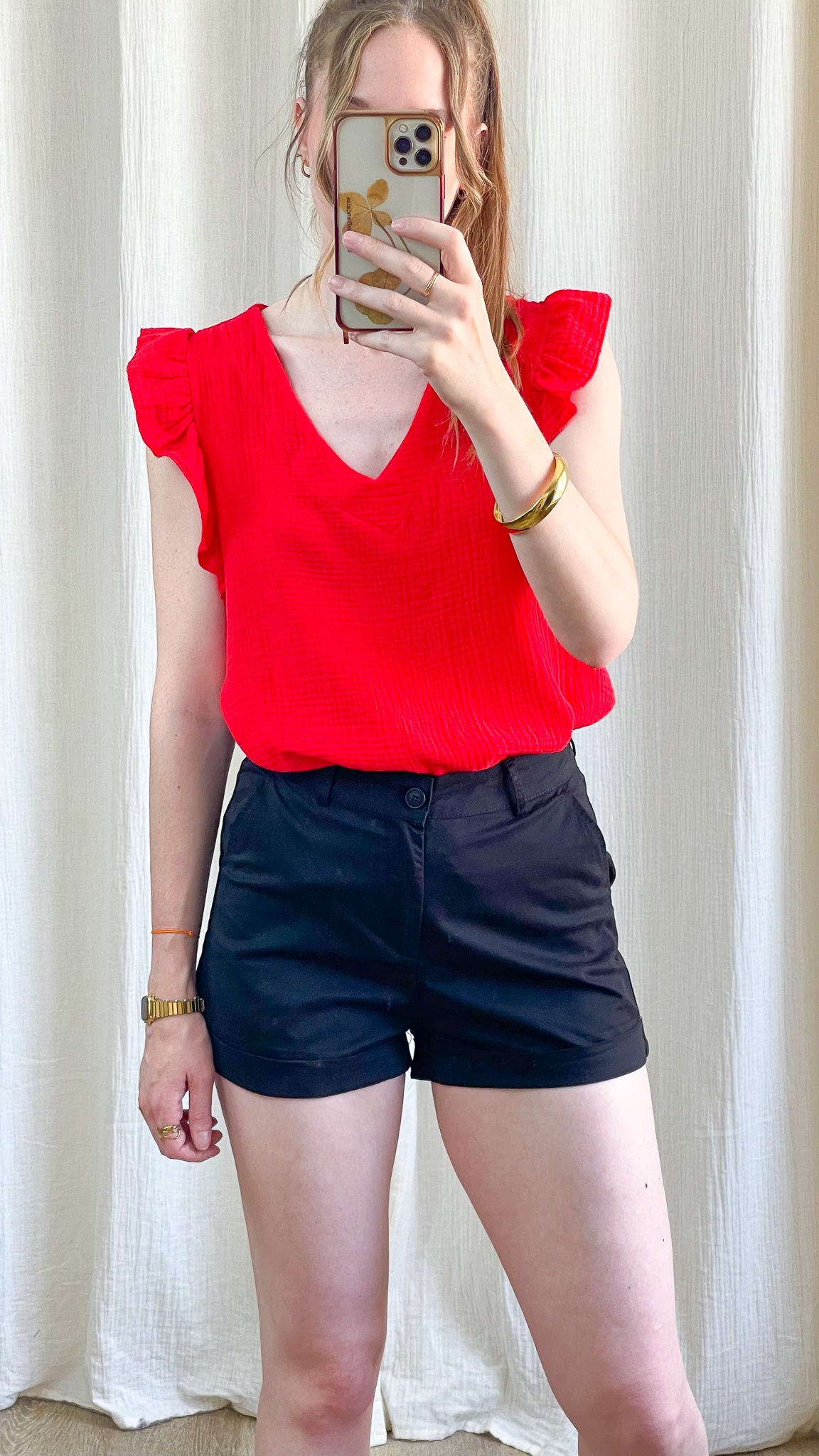 Short noir taille haute coupe chino femme porté avec top rouge à volants, look casual chic été