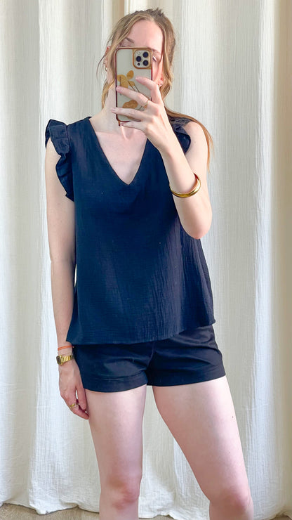 Top Suzanne bleu marine femme col V avec manches à volants en tissu fluide porté avec short assorti style casual chic