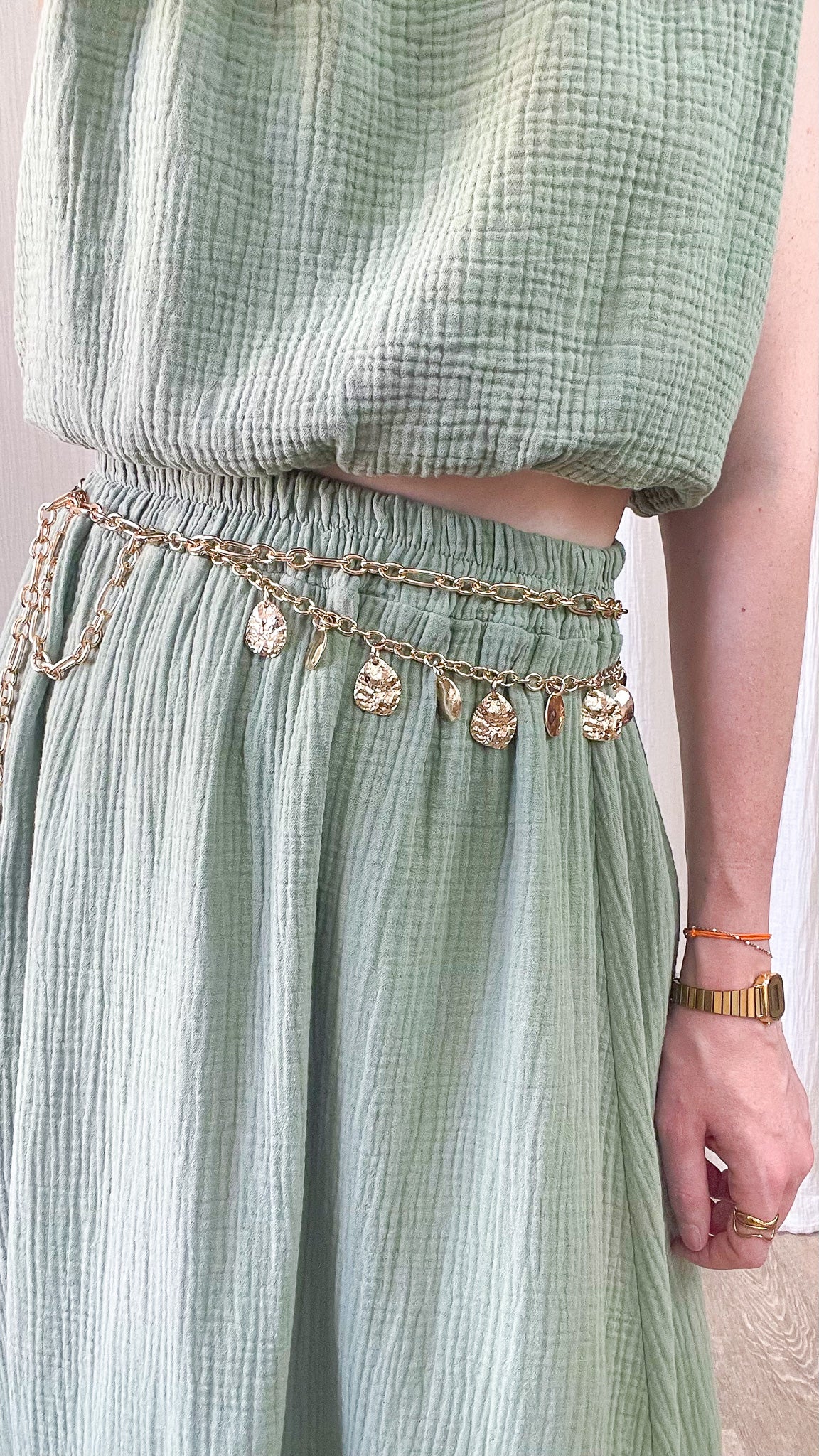 Ceinture double chaînes dorées avec médaillons décoratifs style bohème chic femme portée sur ensemble vert sauge