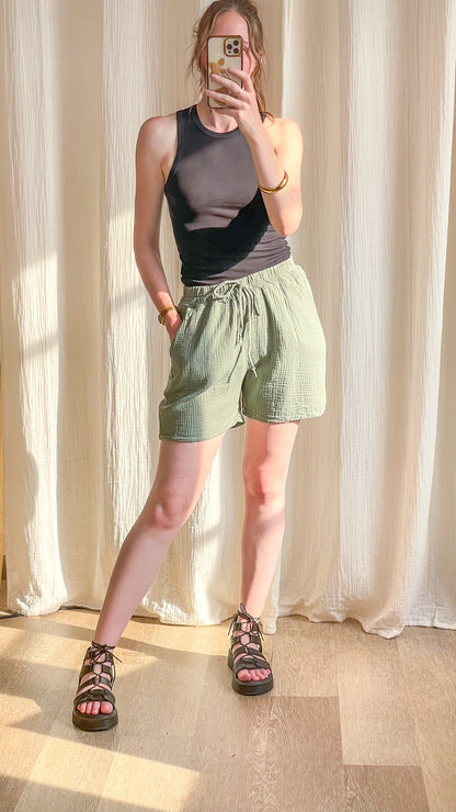 Short fluide vert sauge en gaze de coton taille élastique avec lien à nouer porté avec débardeur noir femme été