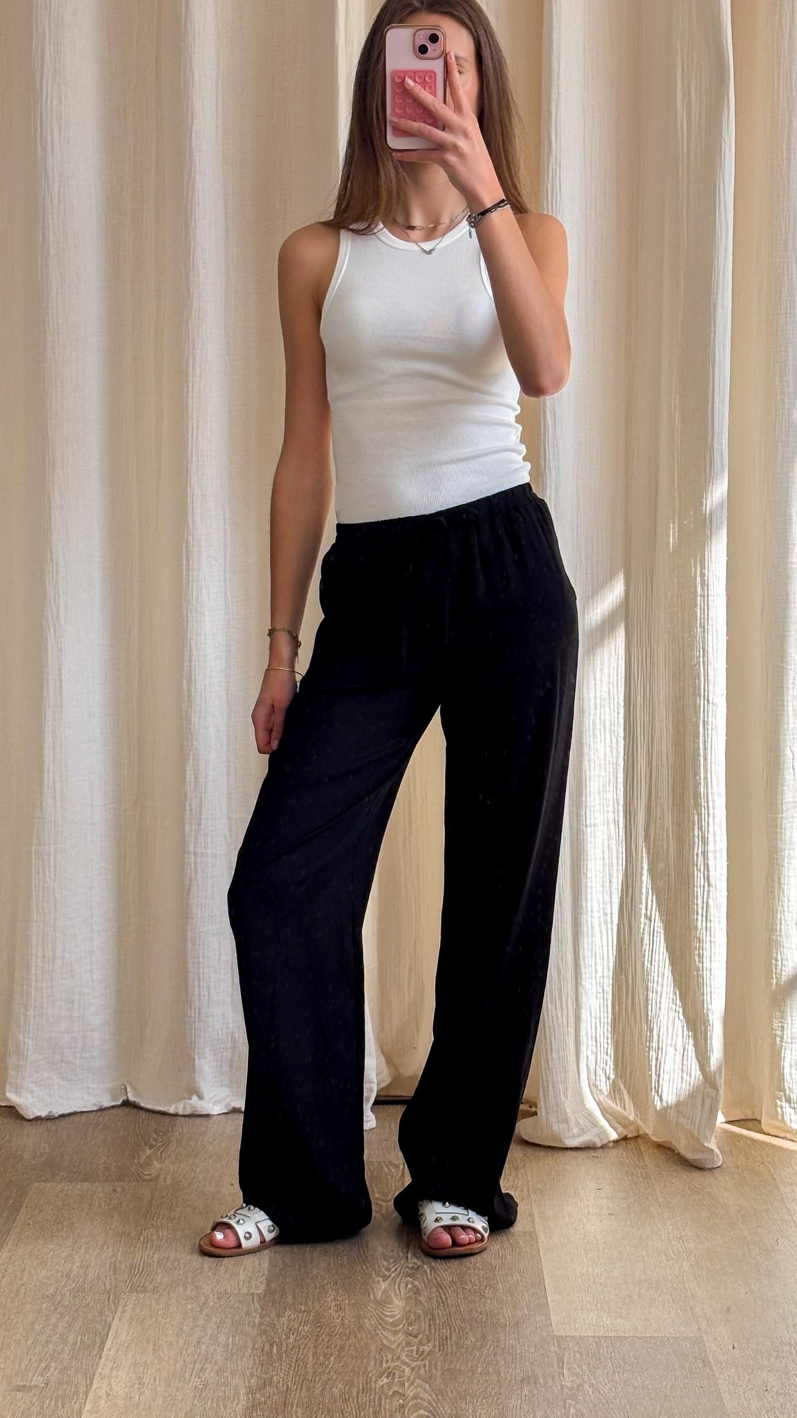 Pantalon large noir fluide taille élastiquée porté avec débardeur blanc, style casual chic femme été