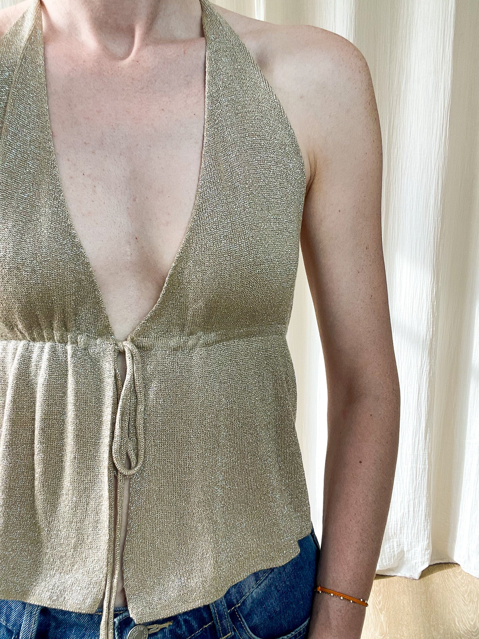 Top femme doré brillant col V plongeant style halter avec lien à nouer, matière lurex légère pour soirée ou été