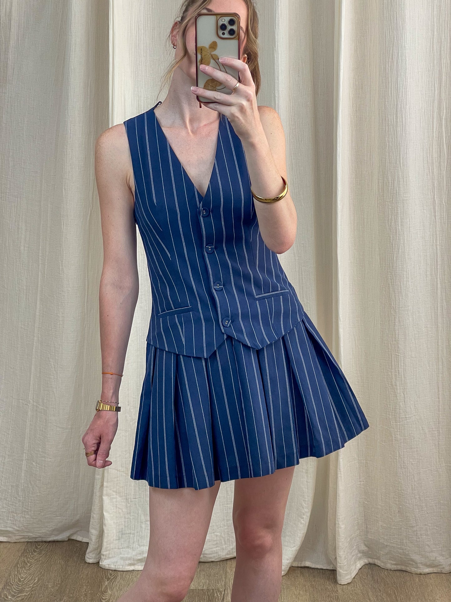 Robe Stormi bleu marine à rayures fines blanches style tailleur avec gilet et jupe plissée femme tendance