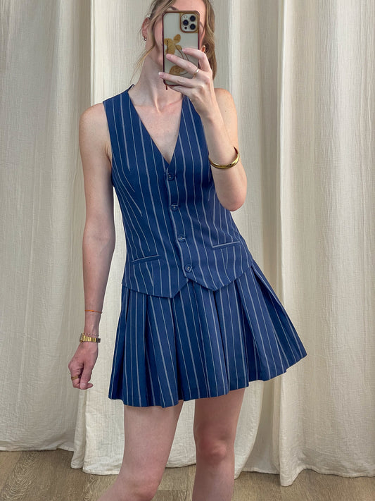 Robe Stormi bleu marine à rayures fines blanches style tailleur avec gilet et jupe plissée femme tendance