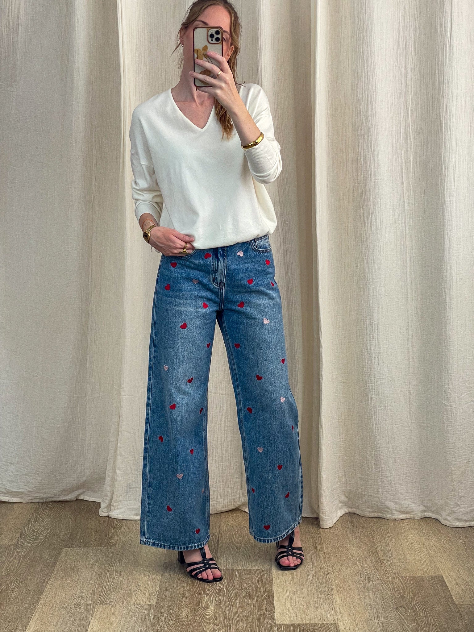 Pull femme col V blanc cassé manches longues porté avec jean large brodé cœurs rouges et roses style casual chic