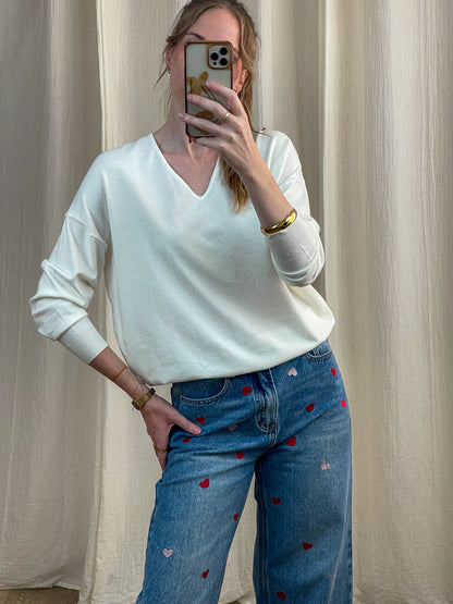 Pull col V blanc cassé femme porté avec jean taille haute brodé coeurs rouges, style casual chic