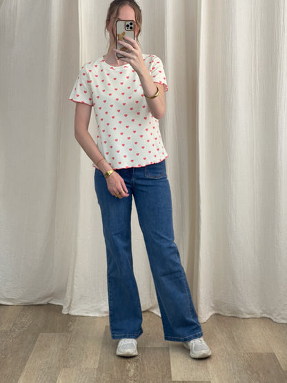 T-shirt blanc imprimé cœurs rouges manches courtes femme porté avec jean flare bleu tenue casual
