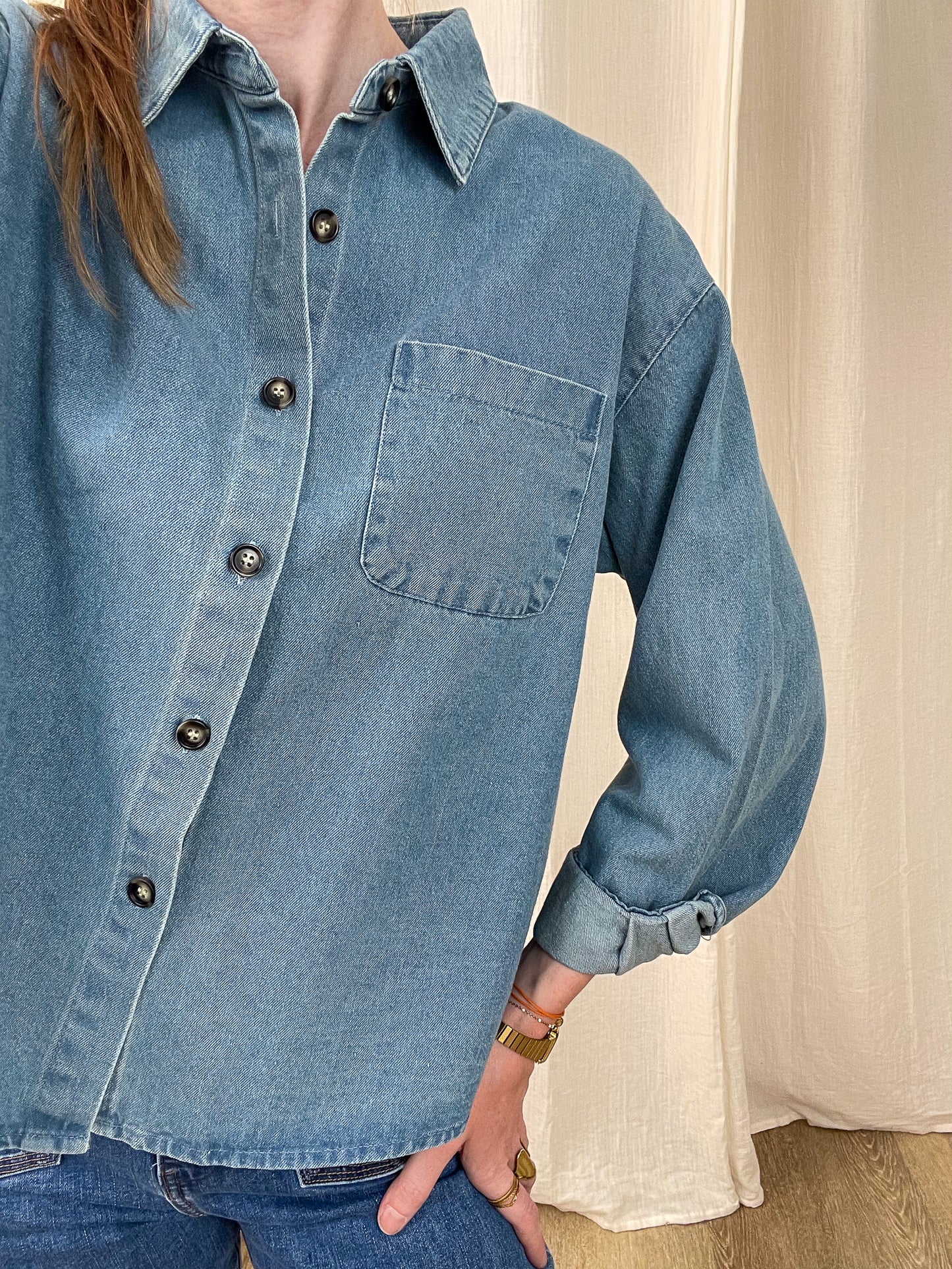 Chemise en jean bleu délavé femme coupe oversize avec poche poitrine et boutons contrastants style casual