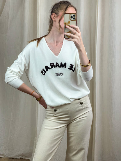 Pull col V blanc cassé femme avec inscription Le Marais Paris en lettres noires brodées style parisien chic décontracté