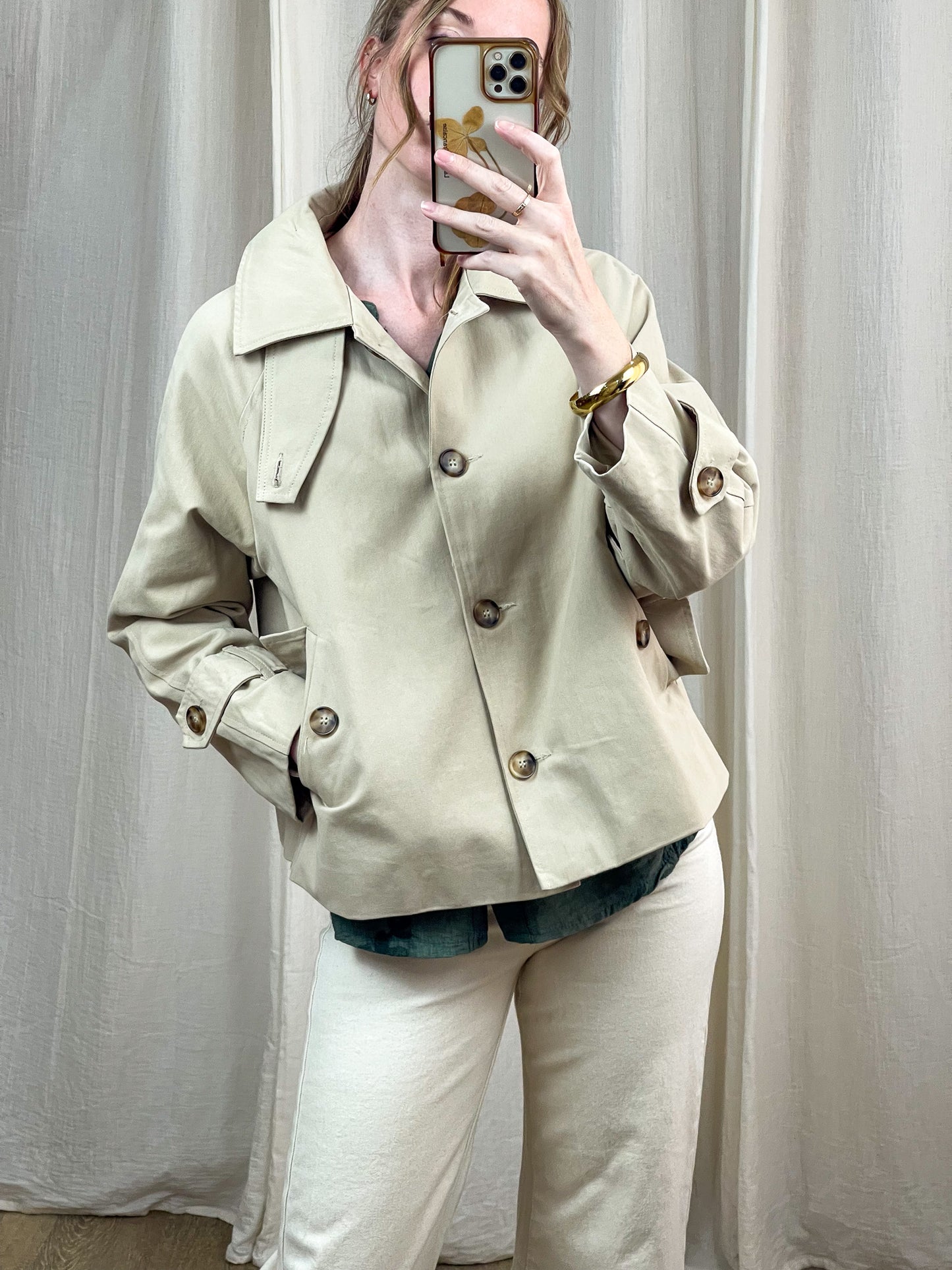 Trench court beige femme coupe oversize avec boutons dorés et col large style minimaliste chic