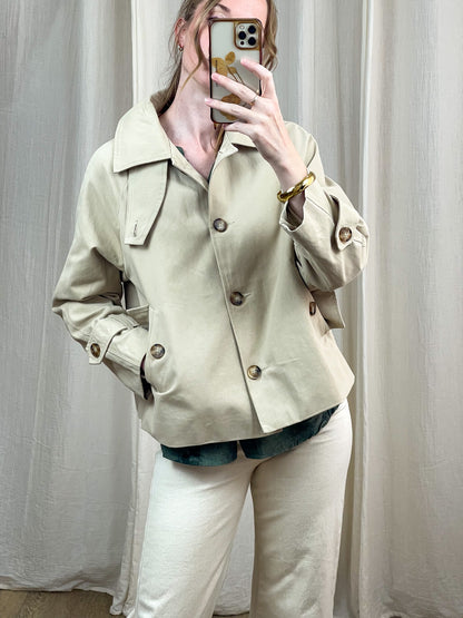 Trench court beige femme coupe oversize avec boutons dorés et col large style minimaliste chic