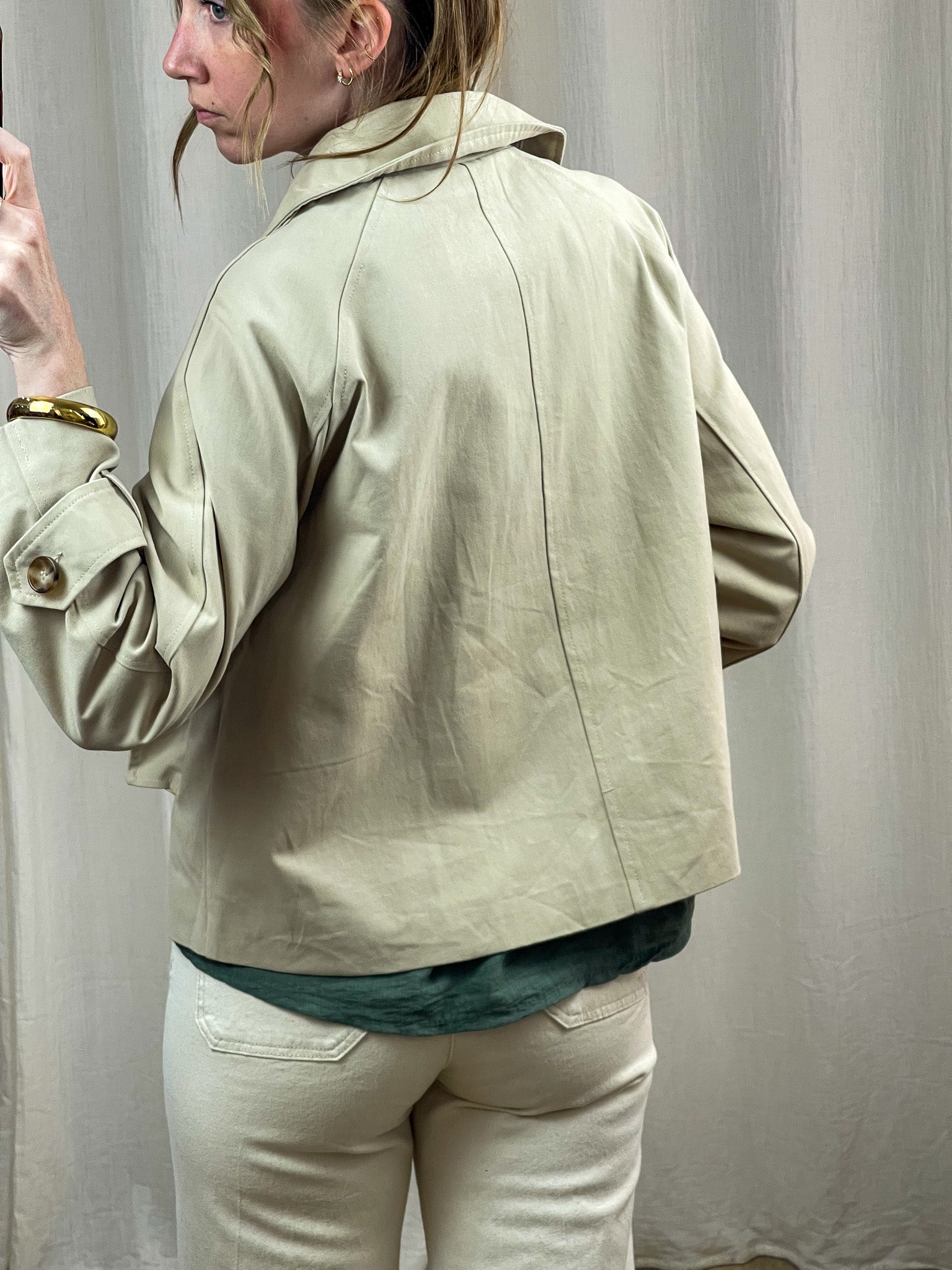 Trench court beige femme coupe oversize avec col relevé et boutons dorés, style vintage chic printemps