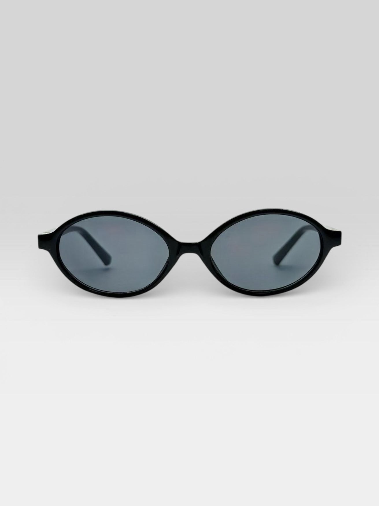 Lunettes de soleil ovales noires style rétro années 90 monture fine accessoire mode femme