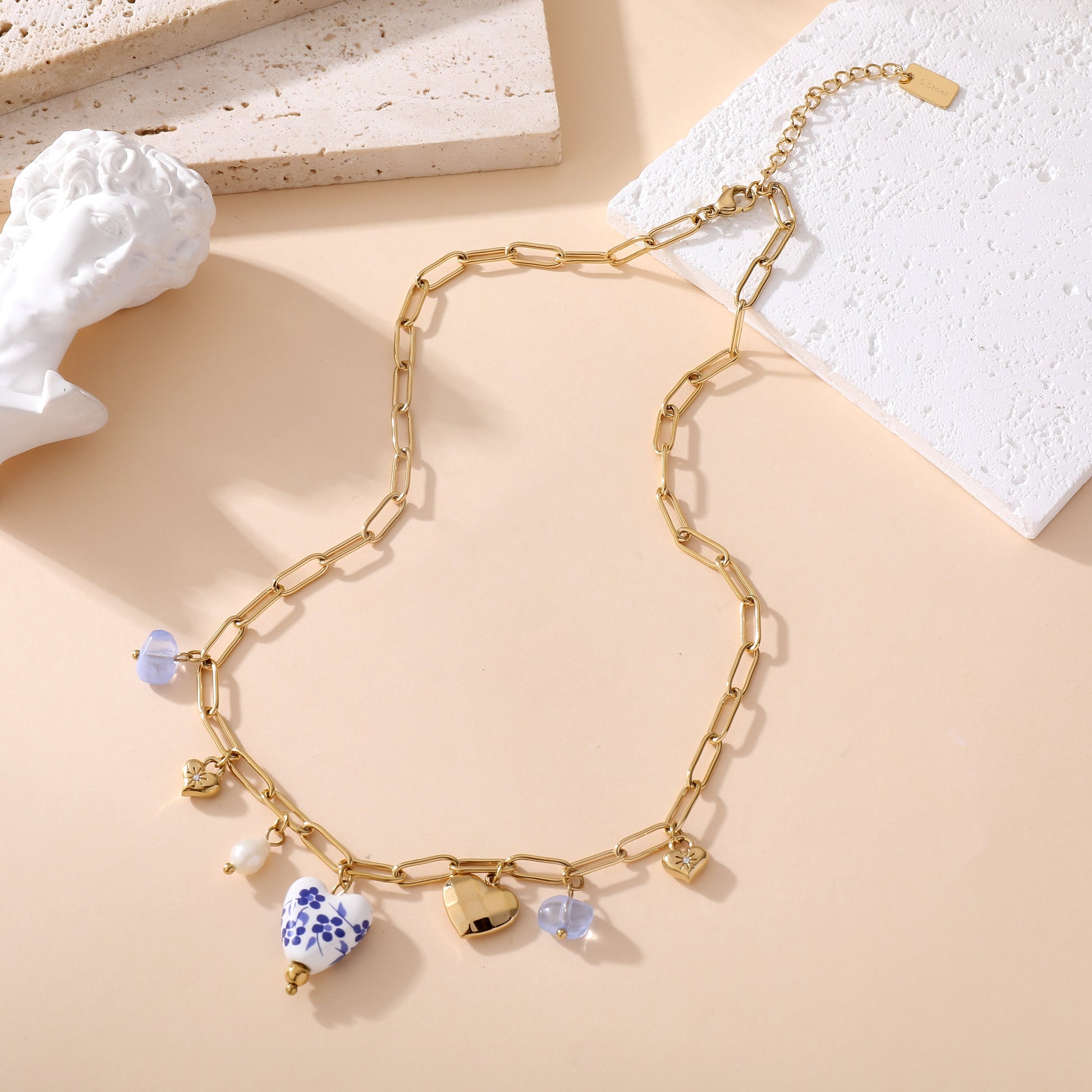 Collier chaîne dorée maille rectangle avec pendentifs cœurs céramique blanc bleu floral et perles femme style bohème chic