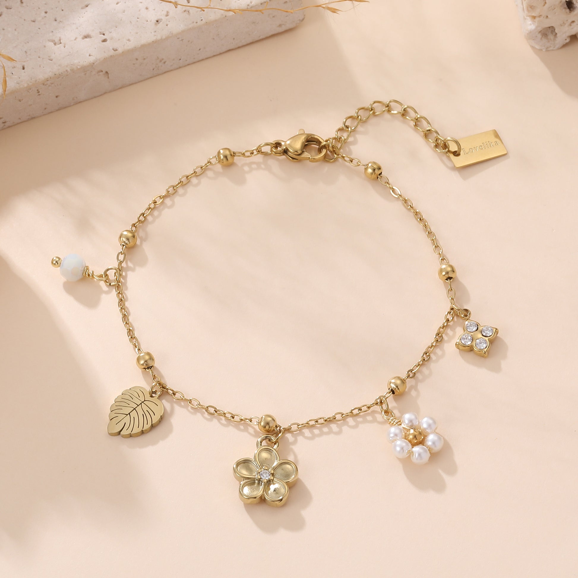 Bracelet chaîne doré femme avec breloques fleur, feuille monstera et perles blanches style bohème chic Lovelika