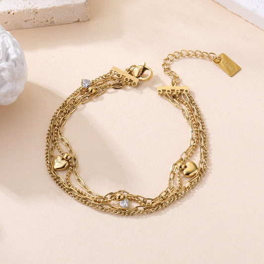 Bracelet quadruple rangs chaînes dorées acier inoxydable avec breloques cœurs et strass femme tendance