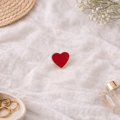 Pin’s cœur rouge émaillé avec contour doré sur fond lifestyle