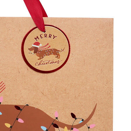 Sac cadeau kraft beige imprimé teckel de Noël avec étiquette ronde chien décoré guirlande lumineuse déco fêtes