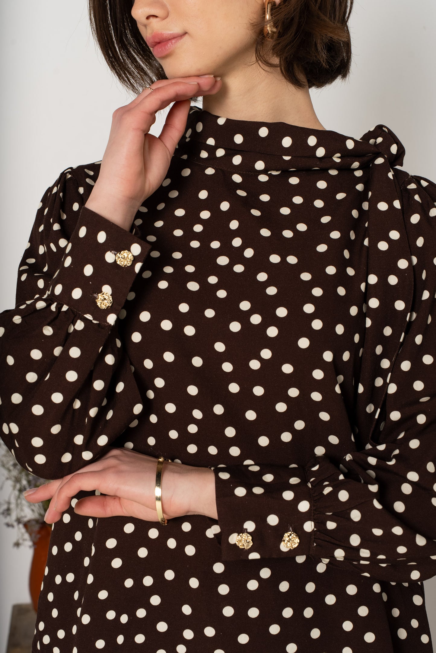 Détail blouse à pois marron manches longues poignets boutons
