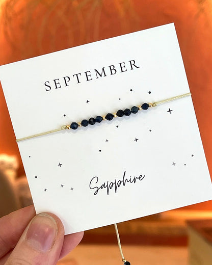 Bracelet cordon beige ajustable pierre de naissance saphir bleu septembre femme avec perles dorées