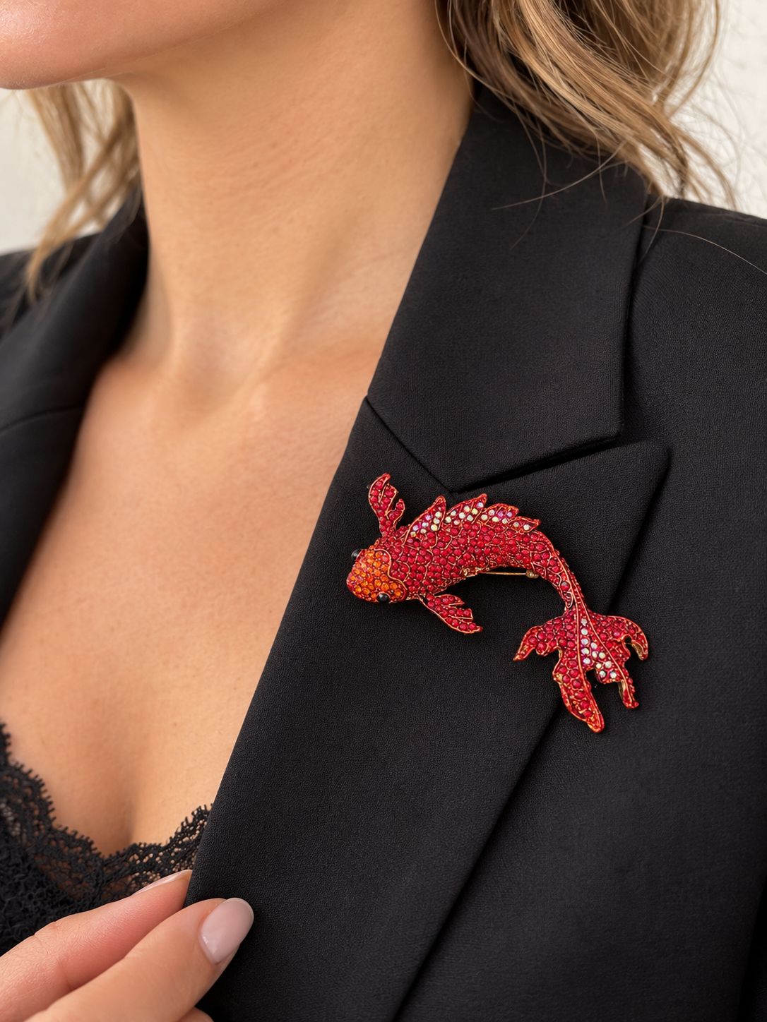 Broche poisson carpe koï rouge ornée de strass scintillants portée sur blazer noir femme accessoire fantaisie élégant