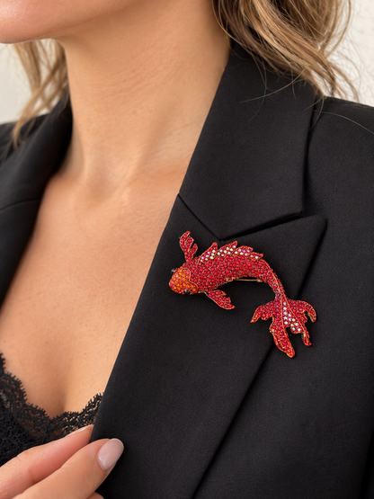 Broche poisson carpe koï rouge ornée de strass scintillants portée sur blazer noir femme accessoire fantaisie élégant