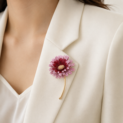 Broche marguerite rose et bordeaux avec tige dorée portée sur blazer crème, accessoire fleur élégant femme