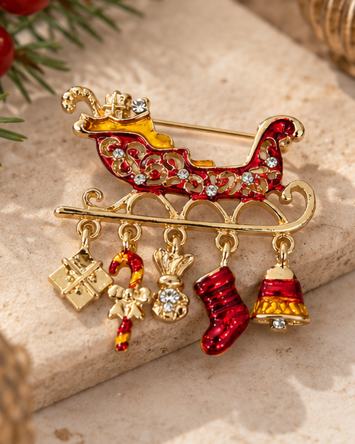 Broche traîneau de Noël dorée et rouge avec breloques cadeau bonbon chaussette et cloche ornée de strass femme