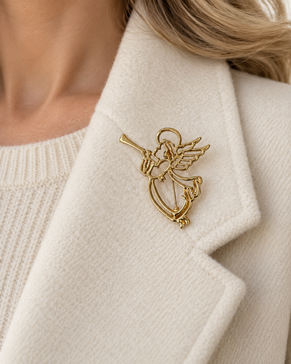 Broche ange dorée ajourée avec trompette et harpe portée sur revers manteau crème femme accessoire bijou fantaisie