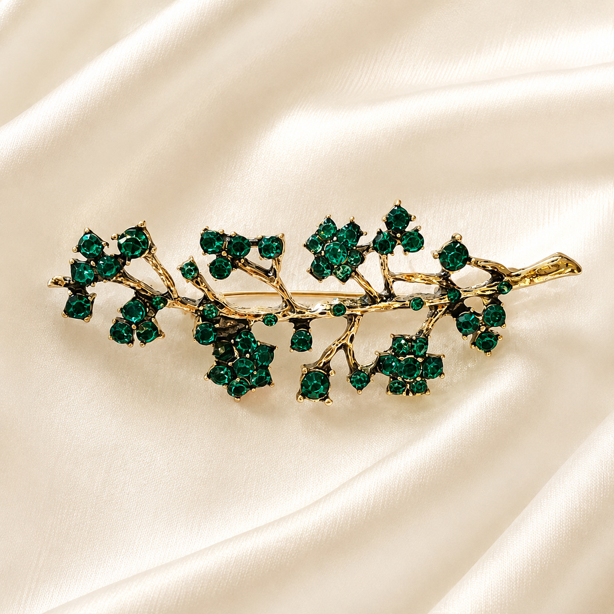 Broche branche fleurie dorée ornée de cristaux verts émeraude, accessoire bijou élégant style vintage femme
