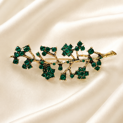 Broche branche fleurie dorée ornée de cristaux verts émeraude, accessoire bijou élégant style vintage femme