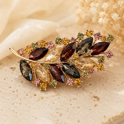 Broche feuille dorée ornée de cristaux multicolores automne tons bordeaux ambre et gris accessoire femme élégant