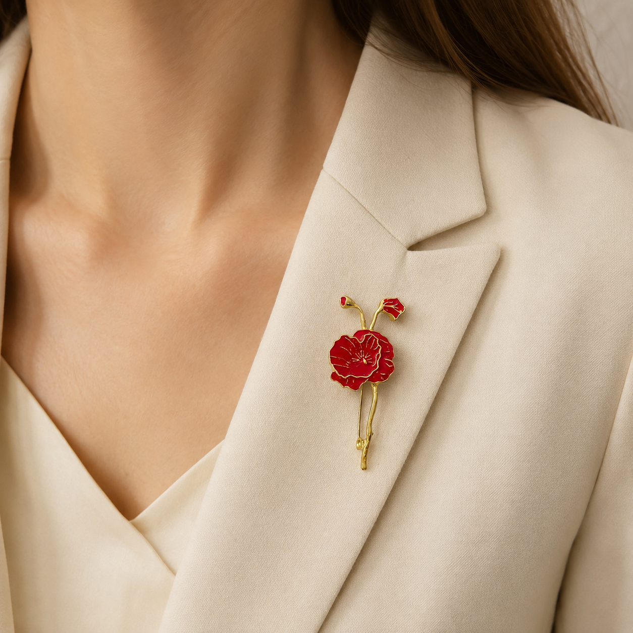 Broche fleur de pavot rouge et dorée portée sur blazer beige femme, accessoire élégant style vintage