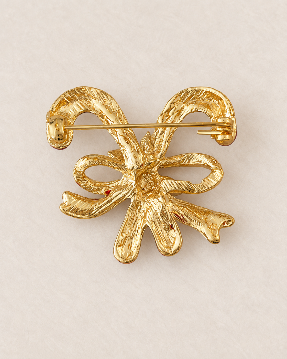 Broche sucre d'orge dorée avec nœud décoratif texturé, accessoire fantaisie femme style festif Noël