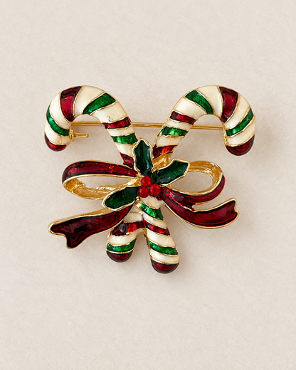 Broche sucre d'orge de Noël dorée émaillée rouge vert et blanc motif cannes à sucre et nœud holly accessoire festif femme