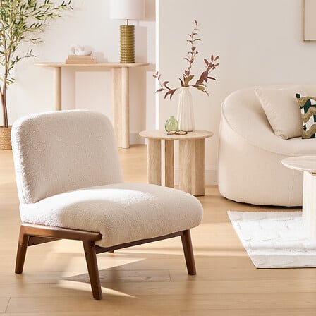 Fauteuil bouclette ivoire Liora avec pieds en bois foncé style scandinave cosy pour salon moderne