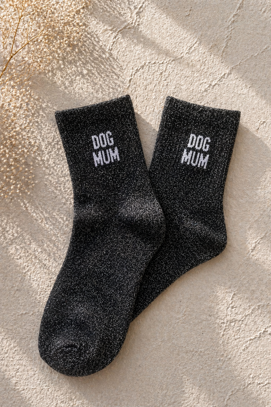 Chaussettes pailletées noir avec inscription DOG MUM brodée en blanc sur fond clair texturé