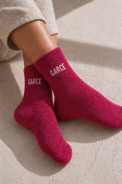 Chaussettes pailletées rose GARCE portées avec inscription blanche visible sur la cheville effet scintillant