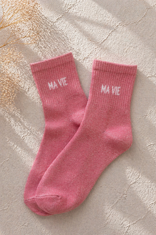 Chaussettes pailletées rose avec inscription MA VIE brodée en blanc sur fond clair texturé