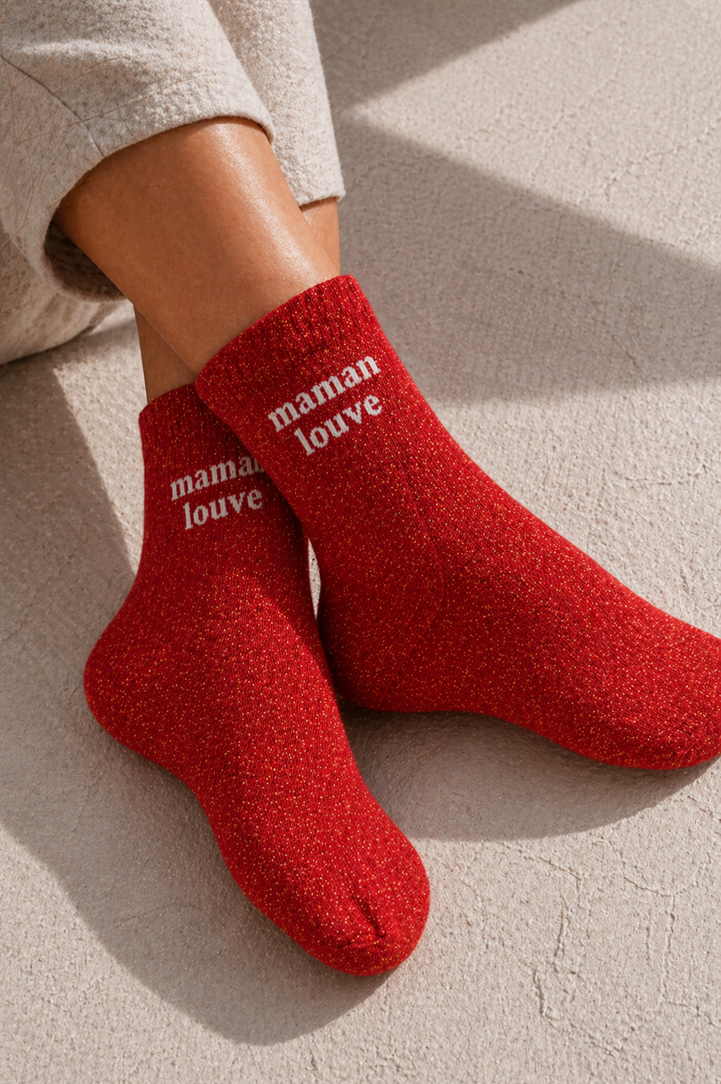 Chaussettes pailletées rouge maman louve portées avec inscription visible sur la cheville effet scintillant