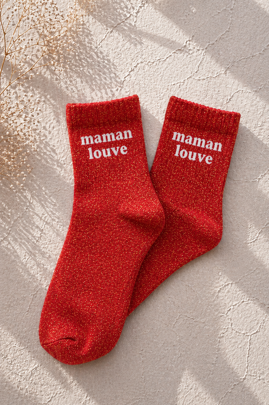 Chaussettes pailletées rouge maman louve avec inscription brodée en blanc sur fond clair texturé