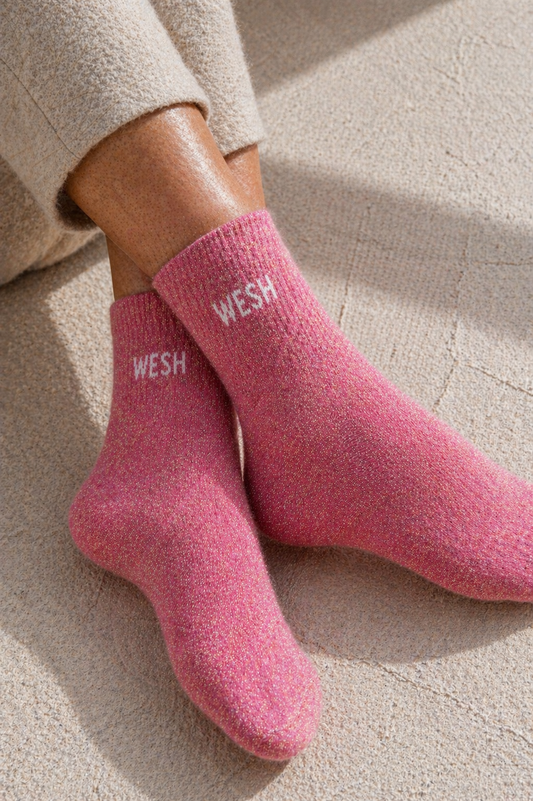 Chaussettes pailletées rose WESH portées avec inscription blanche visible sur la cheville effet scintillant