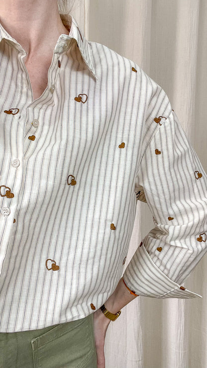 Détail tissu chemise écru rayée avec motifs cœurs brodés