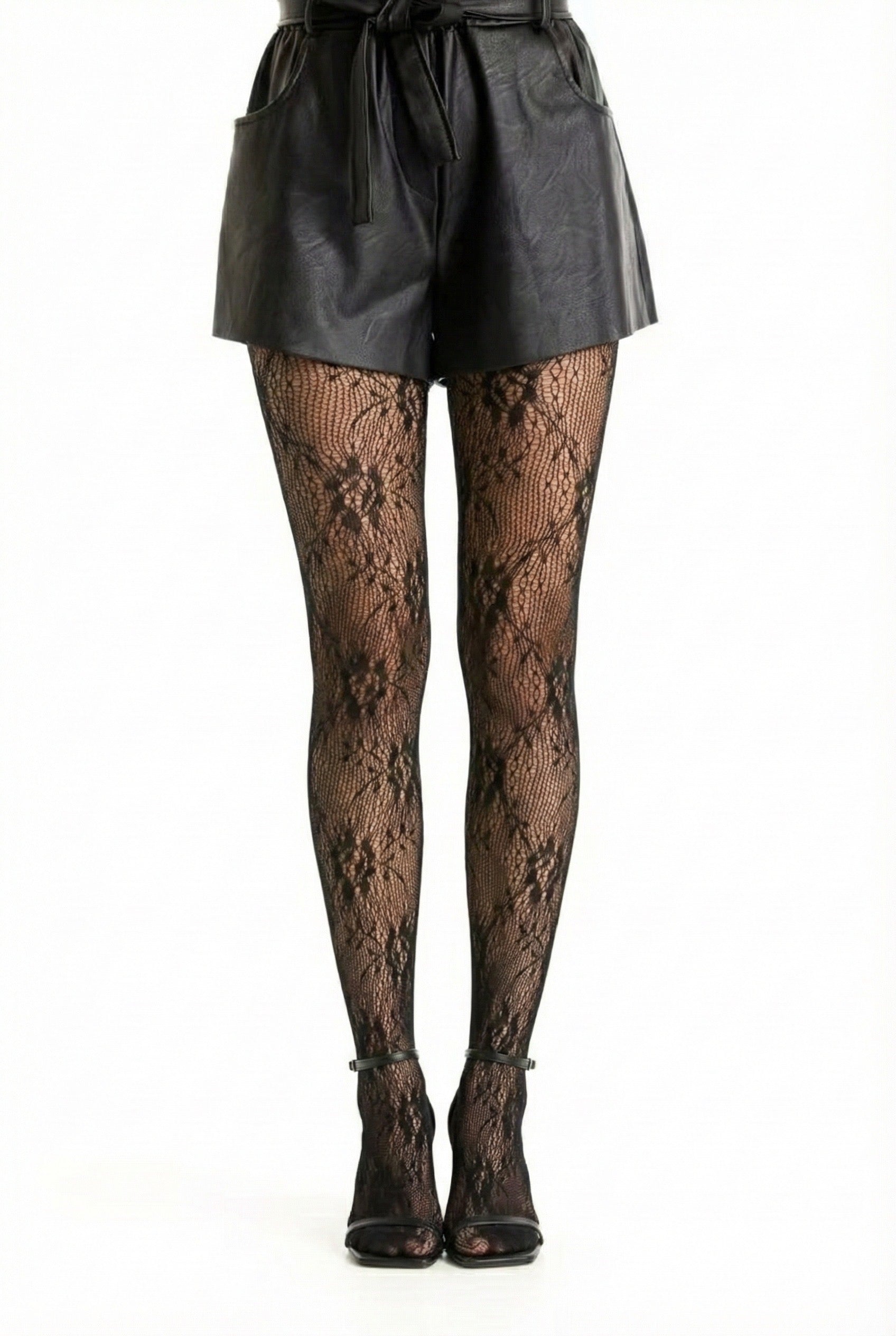 Collant noir en résille et dentelle florale porté avec un short noir