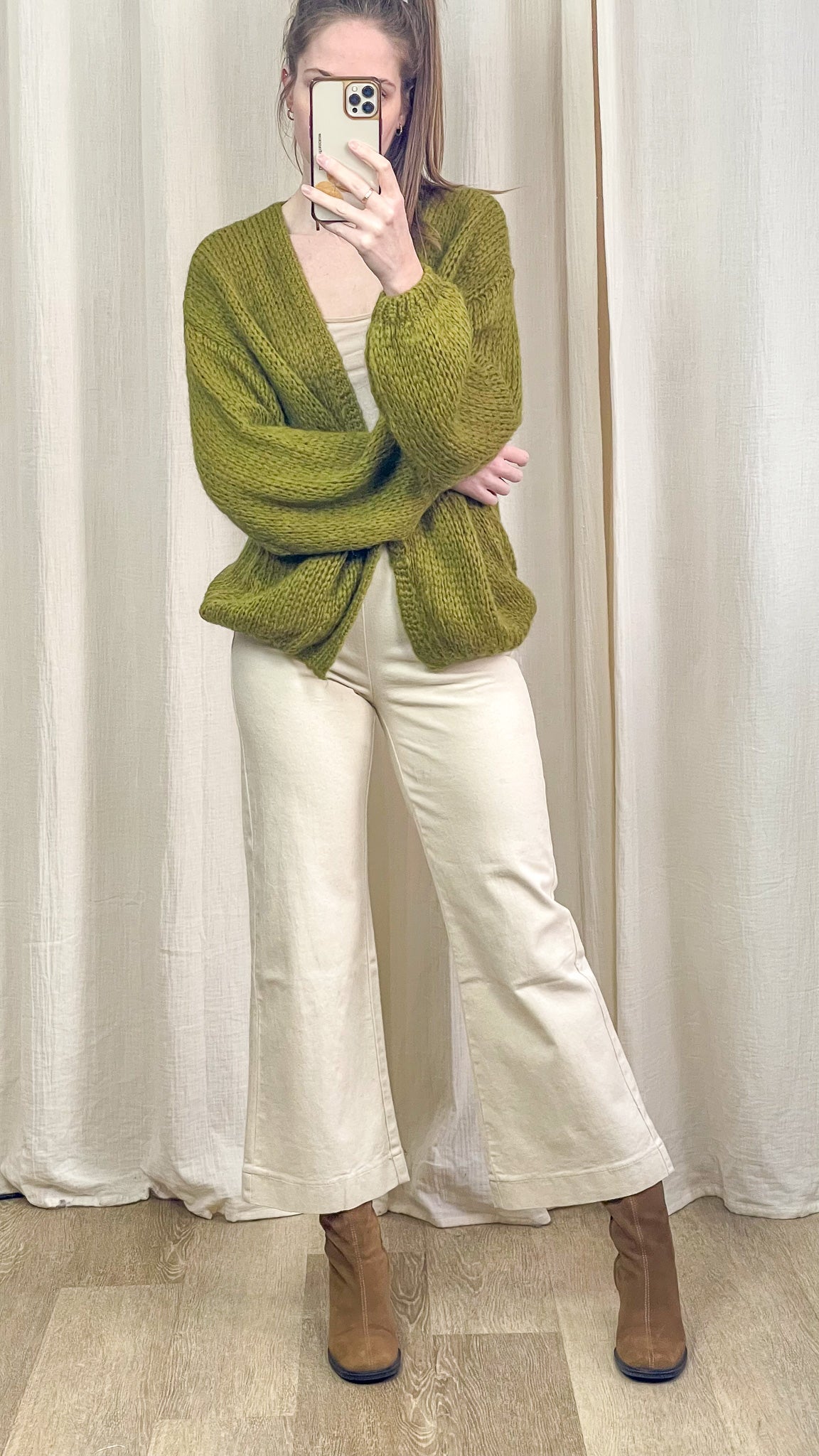 Gilet vert oversize porté avec pantalon écru et bottines look complet