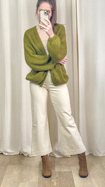 Gilet vert oversize porté avec pantalon écru et bottines look complet