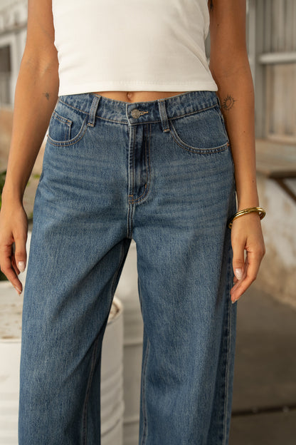 Jean Oraije Brune coupe barrel en denim bleu porté de face en extérieur