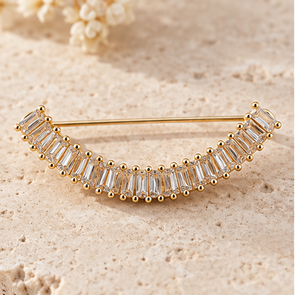 Broche dorée arc élégant ornée de cristaux baguette transparents, accessoire bijou femme cérémonie mariage