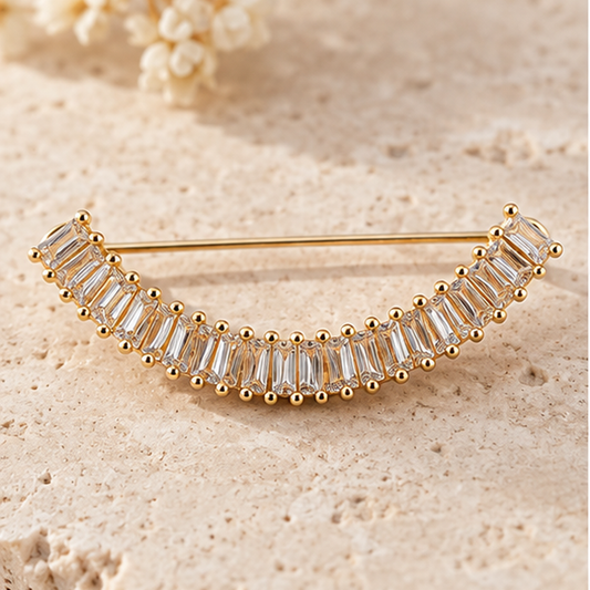 Broche dorée arc élégant ornée de cristaux baguette transparents, accessoire bijou femme cérémonie mariage