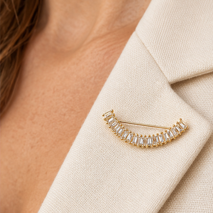 Broche dorée arc de cristaux baguette transparents portée sur revers blazer lin beige accessoire femme élégant